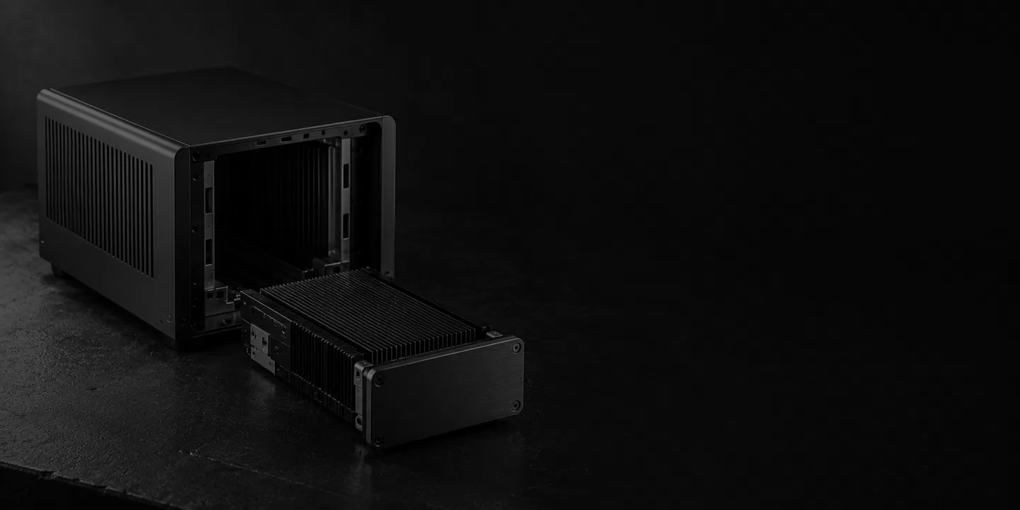 Greyscale conceptual metal compute chassis with an open bay and a removable finned cartridge on a dark workbench.