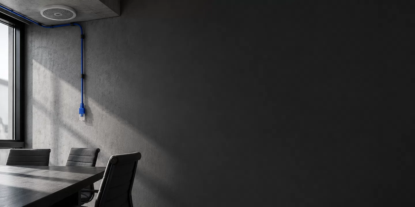 Monochrome conceptual meeting room with a ceiling speaker and cobalt network cable.